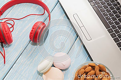 Open laptop with, marshmallows and red headphones. Stock Photo