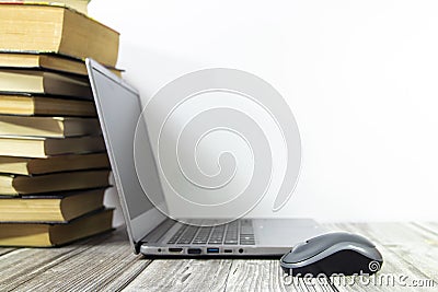 An open laptop on the table near the stack of books. Focus on the bear in front. Place for text. Stock Photo