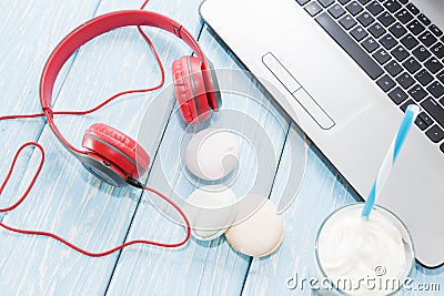 Open laptop with white Cup of coffee, marshmallows and red headphones. Stock Photo