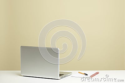 Open laptop on white desk with note pad Stock Photo