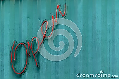 Open letter neon sign on the blue steel wall Stock Photo