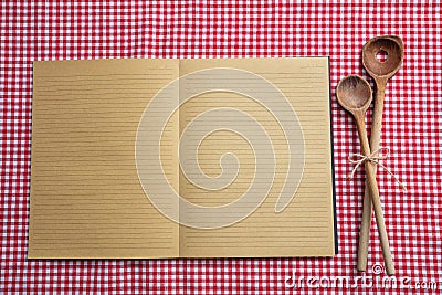 Open notebook, wooden kitchen utensils on red tablecloth, top view, copy space Stock Photo