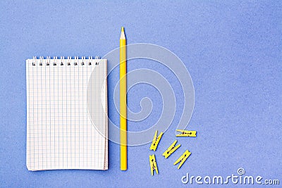 Open notepad in a cage on a spiral, yellow pencil and clamps Stock Photo