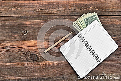 Open Notepad, Pencil And Dollars Cash On Rough Wood Background Stock Photo