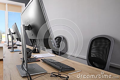 Open office interior. Modern workplaces with computers near light grey wall Stock Photo