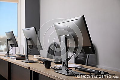 Open office interior. Modern workplaces with computers near light grey wall Stock Photo