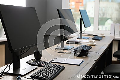 Open office interior. Modern workplaces with computers near window Stock Photo