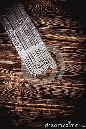 Open pack of welding electrodes on a wooden background. Studio photo in hard light Stock Photo