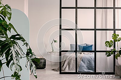 Open plan bedroom interior with mullions wall and king size bed with pillows and blanket Stock Photo