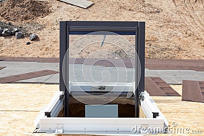 Open plastic mansard or skylight window on a asphalt shingle roof. Stock Photo