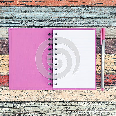 Open purple notebook and pen on vintage wood table for background and text Stock Photo