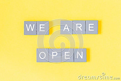 We are open quote, welcome sign for business or caffe, wooden letters on yellow background Stock Photo