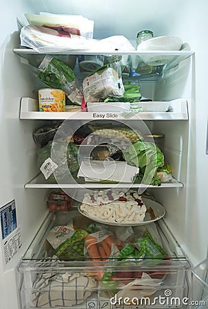 Open refrigerator filled with food in kitchen Editorial Stock Photo