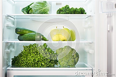 Open refrigerator full of green fruits and vegetables Stock Photo