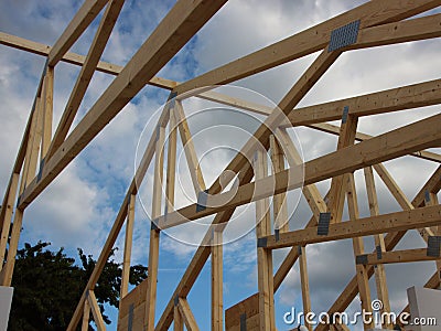 Open Roof Rafter Construction with Sky and Clouds Stock Photo