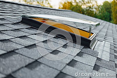 Open roof window on shingles flat polymeric roof-tiles Stock Photo