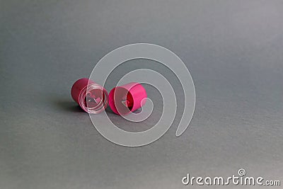 Open round pink plastic sharpener for cosmetic eyeliner pencils on gray blurred background. Copy space Stock Photo