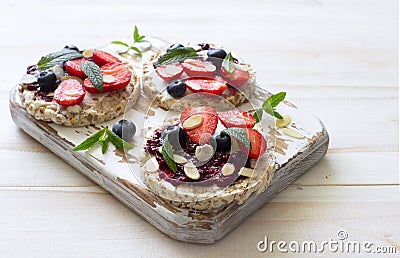 Open sandwiches with cream cheese, strawberries, blueberries, jam and almond flakes close up Stock Photo