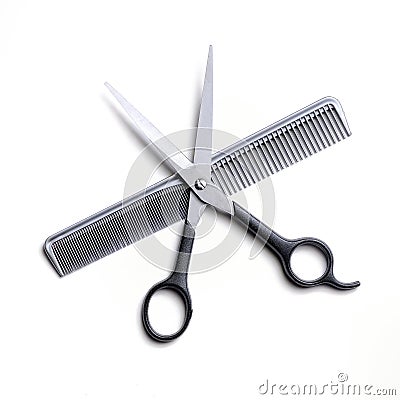 Open scissors on a gray comb isolated Stock Photo