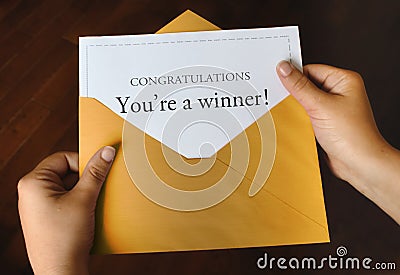 An open shiny gold envelope with a letter that says Congratulations You`re a winner! Stock Photo