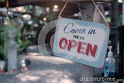 Open sign.Old rusty metal plate with word Come In We`re Open with alcohol gel Stock Photo