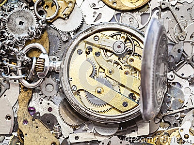Open silver pocket watch on heap of spare parts Stock Photo