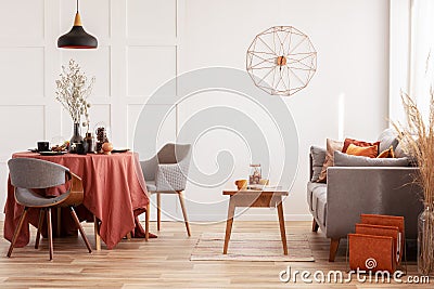 Open space dining and living area with grey scandinavian sofa and table with chairs Stock Photo