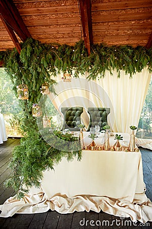 Open terrace in the village style. Catering in a wooden manzanda. Wedding, decor paws ate. Green velvet armchairs. Stock Photo