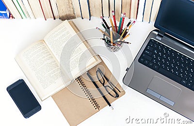 Open textbook, notebook, smartphone, laptop computer, stack of books education back to school background, glasses and pencils in Stock Photo