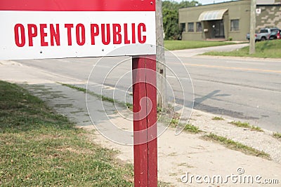 open to public sign on wood wooden post with road and sidewalk behind. ph Stock Photo
