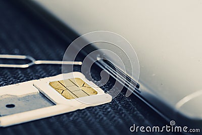 Open Tray of Micro Sim Card Beside Smartphone Stock Photo