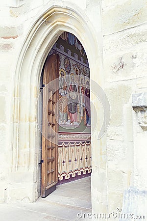 open wood door revealing painted wall in Putna Monastery, Bucovina, Romania Stock Photo