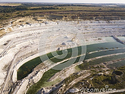 Opencast mining quarry with machinery at work - Aerial view. Industrial Extraction of lime, chalk, calx, caol. View from above Stock Photo