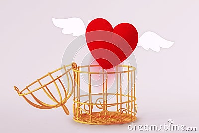 Opened bird cage with escaping heart - Concept of love and freedom Stock Photo