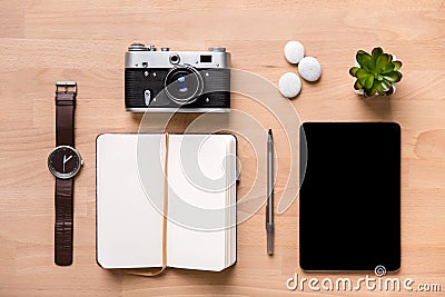 Opened blank notepad, pen, watch, vintage camera, tablet and flower Stock Photo