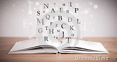 Opened book with flying letters Stock Photo