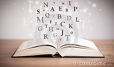 Opened book with flying letters Stock Photo