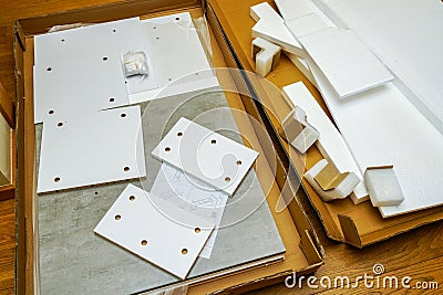 Opened cardboard packaging with new laminated chipboard parts for furniture assembly Stock Photo