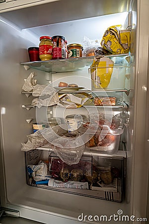 Opened and filled refrigerator in kitchen Editorial Stock Photo