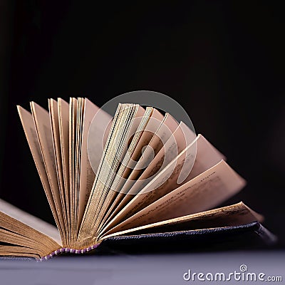 Opened old book with gold pages on a black background Stock Photo