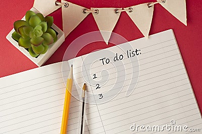 Opened organizer with a to do list inscription, white blank paper pages. Work table with decorative succulent and office supplies Stock Photo