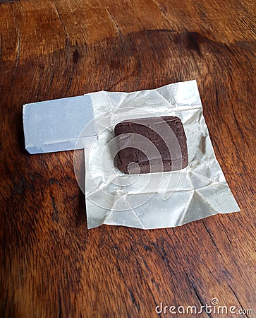 an opened pack of beef stock cubes with silver foil paper wrappers on an old vintage wooden tray Stock Photo