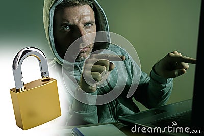Opened padlock composite with young dangerous and skilled hacker manprogramming on laptop computer system cracking password in Stock Photo