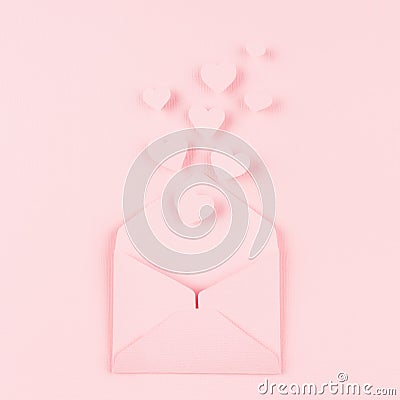 Opened paper envelope with fly out hearts as love message on soft pink color background. Valentine day concept for design. Stock Photo