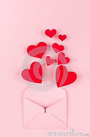 Opened paper envelope with red hearts as love message on soft pink color background. Valentine day concept for design. Stock Photo