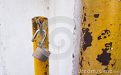 opened unlocked padlock on rusty yellow pole Stock Photo