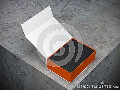 Opened white box with orange interior part and black box inside on concrete table Stock Photo