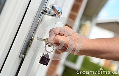 Opening a door to house with key Stock Photo