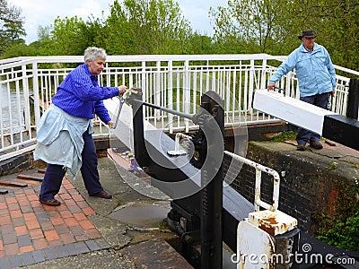 Couple opening canal lock gates Editorial Stock Photo