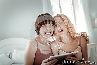 Openly laughing attractive girls hugging each other Stock Photo
